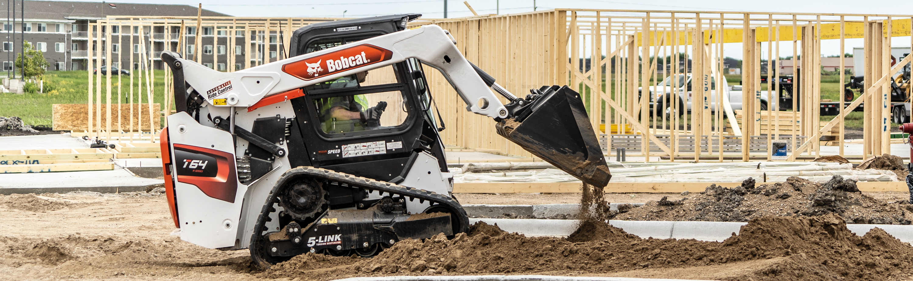 A Bobcat excavator digs on a new home construction site.
